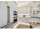 Modern kitchen with white cabinets, stainless steel appliances, gold hardware, and an eat-in kitchen island at 6452 Summit View Dr, Brooksville, FL 34601
