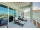 Relax on this covered balcony with water views, ceiling fan, and comfortable seating with matching ottomans at 6613 Josie Ln, Hudson, FL 34667