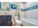 Cozy bathroom featuring tiled walls, deep soaking tub and vibrant, coastal-themed decor at 6613 Josie Ln, Hudson, FL 34667