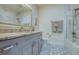 Stylish bathroom featuring patterned tile floors, granite counters, and a marble shower surround at 6613 Josie Ln, Hudson, FL 34667