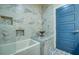 White marble shower with mosaic shelves next to a matching marble topped storage table at 6613 Josie Ln, Hudson, FL 34667