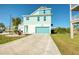 Inviting coastal home with a turquoise garage door and a spacious stamped concrete driveway at 6613 Josie Ln, Hudson, FL 34667