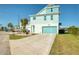 Inviting coastal home with a turquoise garage door and a spacious stamped concrete driveway at 6613 Josie Ln, Hudson, FL 34667