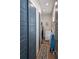 Hallway leading to laundry room with storage cabinets and light-colored decor at 6613 Josie Ln, Hudson, FL 34667