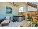 Relaxing outdoor hot tub area with shaded seating, fan, and tropical plants at 6613 Josie Ln, Hudson, FL 34667