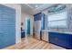 Bright kitchen features stainless steel appliances and blue cabinets and modern hardware at 6613 Josie Ln, Hudson, FL 34667