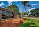 Community entrance sign with 'Timber Greens' inscription, lush landscaping, and a glimpse of the guard house at 6626 Pine Walk Dr, New Port Richey, FL 34655