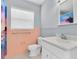 Bathroom with a white vanity, peach tiles, and shower with pink accents at 686 Manor W Dr, Dunedin, FL 34698