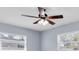 Bedroom featuring a ceiling fan with light fixture, neutral walls, and dual windows at 686 Manor W Dr, Dunedin, FL 34698