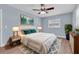 A spacious bedroom with hard wood floors, ceiling fan, and blue accent pillows at 686 Manor W Dr, Dunedin, FL 34698