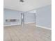 Open living area with white tile floors and light blue walls at 686 Manor W Dr, Dunedin, FL 34698