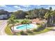 Aerial view of pool and tennis court surrounded by tropical landscape and blue skies at 7109 Kirsch Ct # 2, New Port Richey, FL 34653
