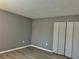 Bedroom featuring gray walls, laminate flooring, and a closet with white doors at 7109 Kirsch Ct # 2, New Port Richey, FL 34653