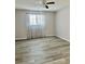 A light-filled bedroom with wood-look flooring and a ceiling fan at 7109 Kirsch Ct # 2, New Port Richey, FL 34653