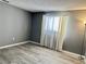 Bedroom featuring gray walls, laminate flooring, and a window with white curtains at 7109 Kirsch Ct # 2, New Port Richey, FL 34653