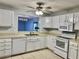 Bright kitchen with white appliances, cabinets, and view into the living area at 7109 Kirsch Ct # 2, New Port Richey, FL 34653