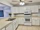 Kitchen featuring white cabinets, appliances, and view into the living room at 7109 Kirsch Ct # 2, New Port Richey, FL 34653