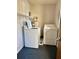 Laundry room features washer, dryer and water heater with storage shelves and blue carpet at 7109 Kirsch Ct # 2, New Port Richey, FL 34653