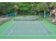 A full tennis court surrounded by green foliage and a high fence at 7109 Kirsch Ct # 2, New Port Richey, FL 34653