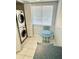 Bright laundry room with a stacked washer and dryer, a small table, and a window at 8150 Brent St # 713, Port Richey, FL 34668