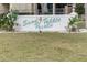 Entrance sign for Sand Pebble Pointe at street level with healthy lawn at 8150 Brent St # 713, Port Richey, FL 34668