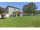 Large, fenced backyard features mature trees and a covered patio at 8788 Fetterbush Ct, Brooksville, FL 34613