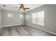 Bedroom featuring hardwood flooring, light gray walls, and two windows at 8788 Fetterbush Ct, Brooksville, FL 34613