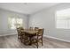 Bright dining area featuring wood-look floors, a large window, and a stylish wooden dining table at 8788 Fetterbush Ct, Brooksville, FL 34613