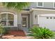 Close-up of the home's entrance showcasing stonework accents and tropical landscaping near the front door at 8788 Fetterbush Ct, Brooksville, FL 34613
