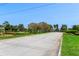 Street view of a beautifully landscaped neighborhood entrance with manicured lawns and decorative trees at 8788 Fetterbush Ct, Brooksville, FL 34613