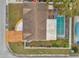 Aerial shot of the house with a large roof, pool, fenced in yard, and surrounded by mature trees at 9220 Saint Regis Ln, Port Richey, FL 34668