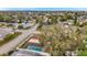 Aerial view of the home showing the backyard pool, screened-in patio, mature trees and surrounding neighborhood at 9220 Saint Regis Ln, Port Richey, FL 34668