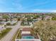 Aerial view of the property with an in-ground pool, screen patio enclosure, fenced yard, and neighborhood streets at 9220 Saint Regis Ln, Port Richey, FL 34668