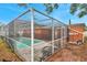 The backyard has a view of the screened-in pool and the house. It has a tile patio and equipment at 9220 Saint Regis Ln, Port Richey, FL 34668