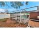 A view of the spacious backyard with a screened-in pool, set against a leafy backdrop at 9220 Saint Regis Ln, Port Richey, FL 34668