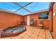 Backyard featuring a tiled patio and hot tub under an awning at 9220 Saint Regis Ln, Port Richey, FL 34668