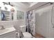 Bathroom featuring white-tiled shower, decorative shower curtain, and updated sink at 9220 Saint Regis Ln, Port Richey, FL 34668