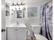 Bathroom featuring white-tiled shower, decorative shower curtain, and updated sink at 9220 Saint Regis Ln, Port Richey, FL 34668