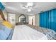 Bedroom featuring bed with ornate headboard, tile floors, and bright blue curtains at 9220 Saint Regis Ln, Port Richey, FL 34668