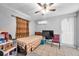 Bedroom with tan tile flooring, ceiling fan, window with curtains, and white door at 9220 Saint Regis Ln, Port Richey, FL 34668