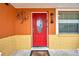 Charming red front door with decorative accents and adjacent window at 9220 Saint Regis Ln, Port Richey, FL 34668