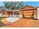Single-story home featuring an attached garage, white picket fence, and an orange driveway at 9220 Saint Regis Ln, Port Richey, FL 34668