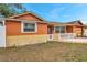 Charming single-story home featuring a white picket fence and colorful orange and yellow exterior at 9220 Saint Regis Ln, Port Richey, FL 34668