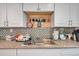 Well-organized kitchen sink area with granite counters, mosaic tile backsplash, and handy dish rack at 9220 Saint Regis Ln, Port Richey, FL 34668