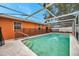 Inviting screened-in pool with easy-access steps and a safety fence, perfect for relaxation and Gathering fun at 9220 Saint Regis Ln, Port Richey, FL 34668