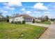 Well-kept home exterior with manicured shrubs, a paved driveway, and an attached garage at 11082 Heathrow Ave, Spring Hill, FL 34609