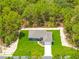 An aerial view of a beautifully landscaped single-Gathering home surrounded by lush greenery and trees at 11345 Thrasher Ave, Weeki Wachee, FL 34614