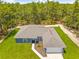 Aerial view showcasing a single-Gathering home with a well-maintained lawn and surrounding trees at 11345 Thrasher Ave, Weeki Wachee, FL 34614