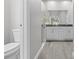 Bathroom featuring double sinks, granite countertop, glass enclosed shower, and wood-look tile flooring at 11345 Thrasher Ave, Weeki Wachee, FL 34614