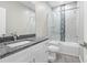 Modern bathroom with granite countertop, white vanity, and tiled shower with glass door at 11345 Thrasher Ave, Weeki Wachee, FL 34614